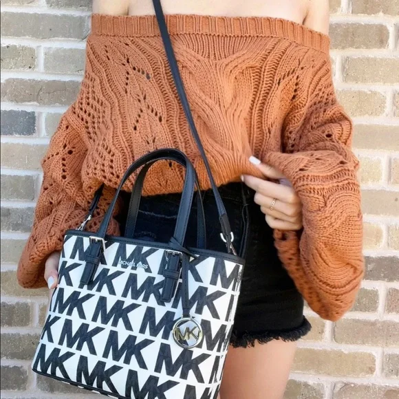 White Michael Kors crossbody with black logo and silver accents